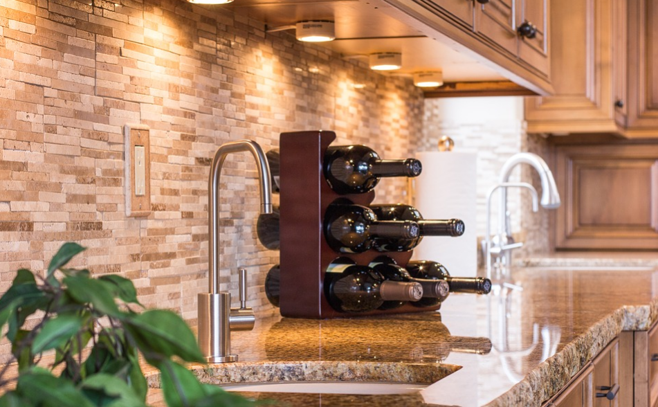 Glossy kitchen countertop with a rack of wine